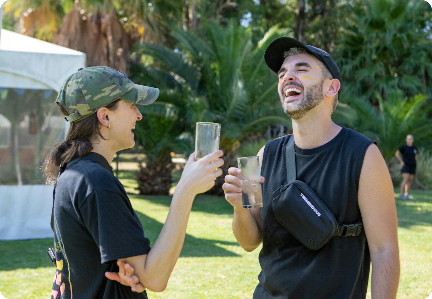 Two Tremendous teammates laughing outdoors during a company gathering