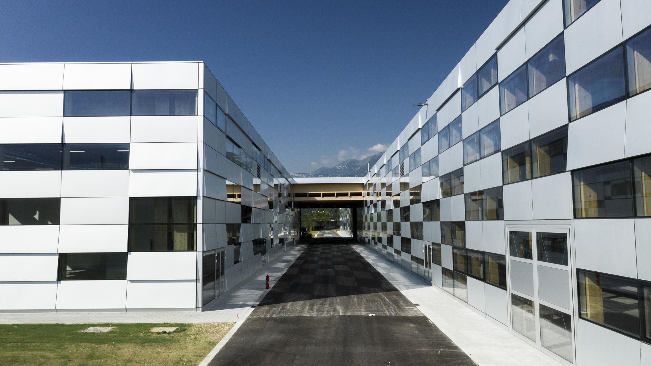 Glass and metal facades lining a passage at the Be Factory production development