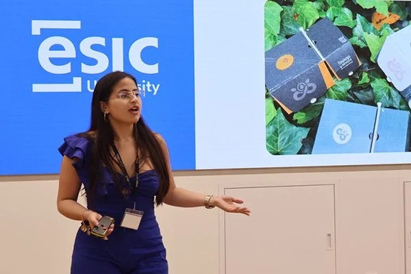 A presenter discusses a product in front of an ESIC University backdrop at a TrepCamp program