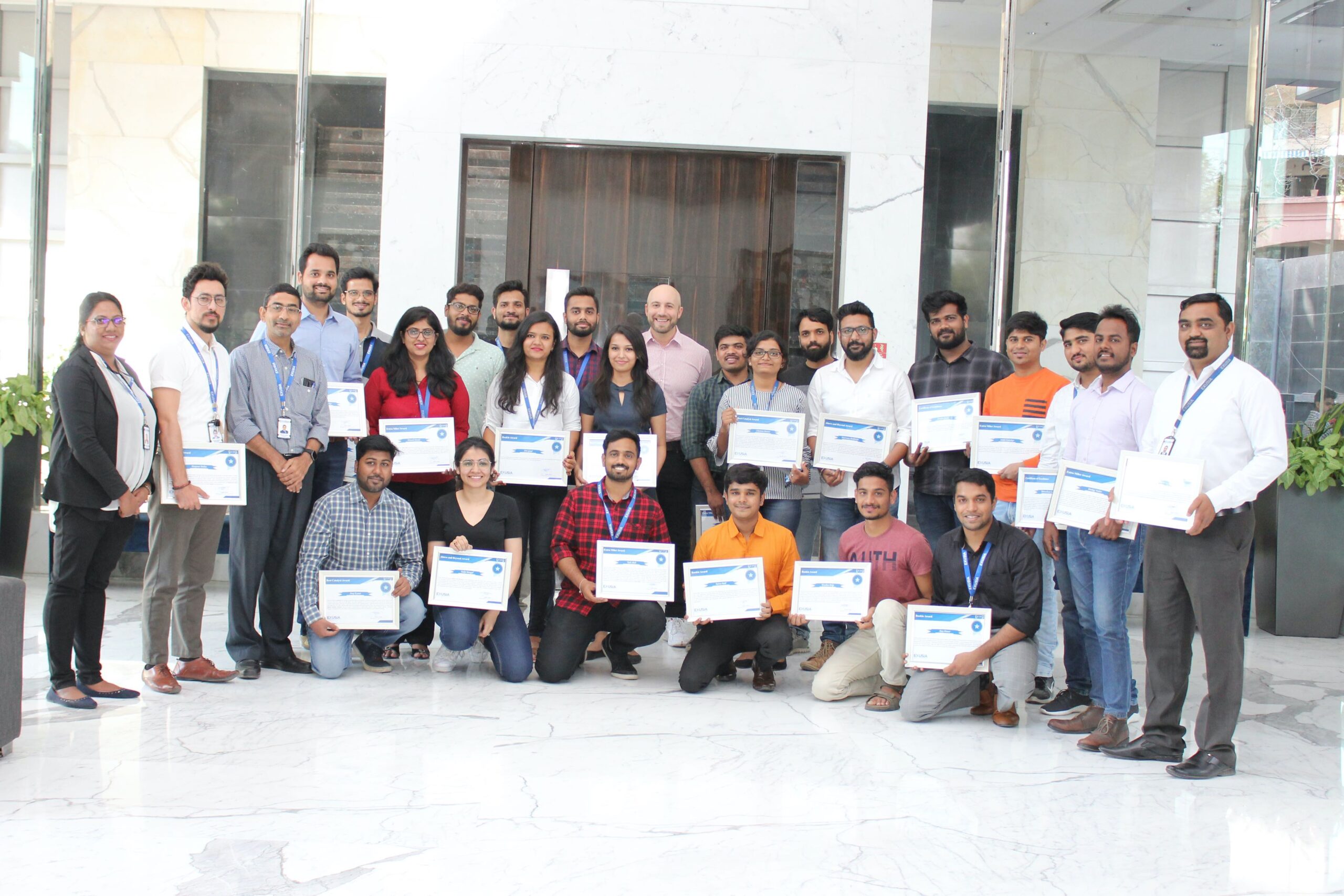 Trevor Silver with Exusia colleagues holding certificates in a group photograph