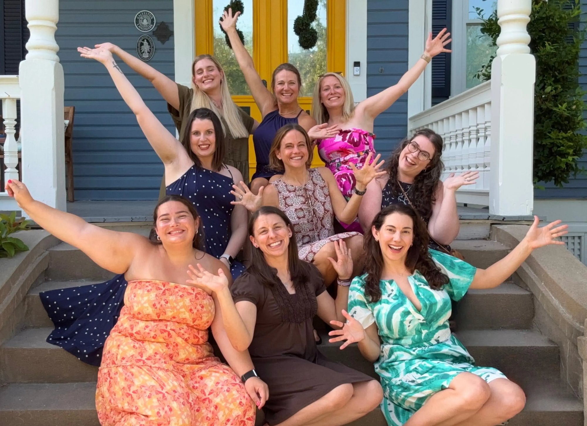 Members of the TREW Marketing team smiling on the steps of a house during the 2026 company retreat