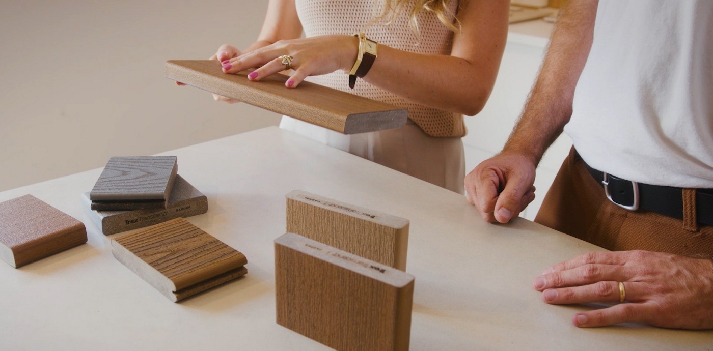 A homeowner compares the color and texture of Trex decking samples