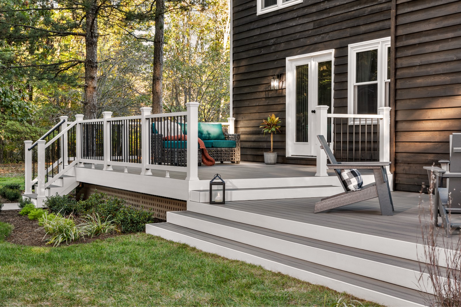 Trex composite deck with white railing, broad steps and Adirondack chairs