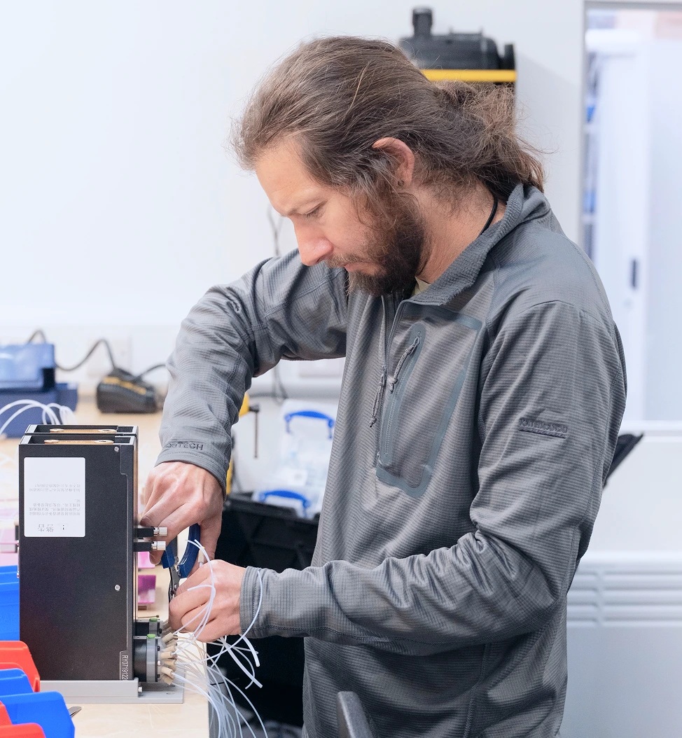 A technician works on a Chemify robotic chemistry instrument