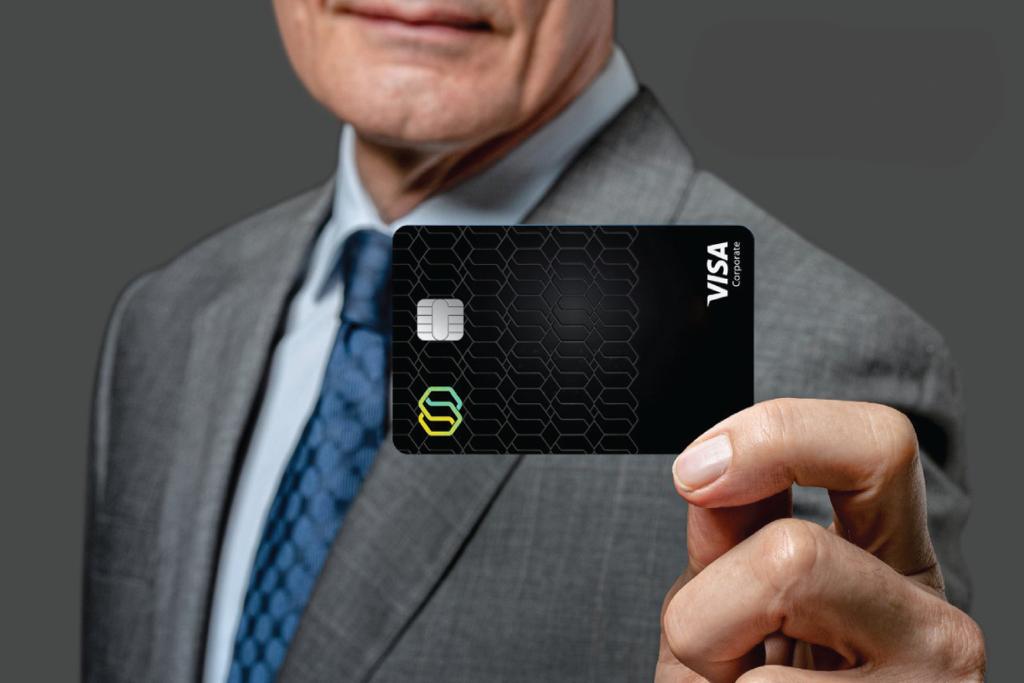 A person holding a black Tribal Visa corporate card
