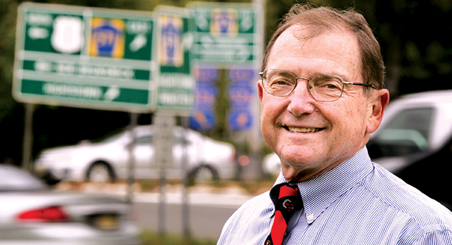 ALK founder Alain Kornhauser standing near road signs in Princeton