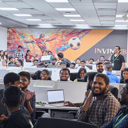 Tringapps employees gathered among office workstations during a company activity