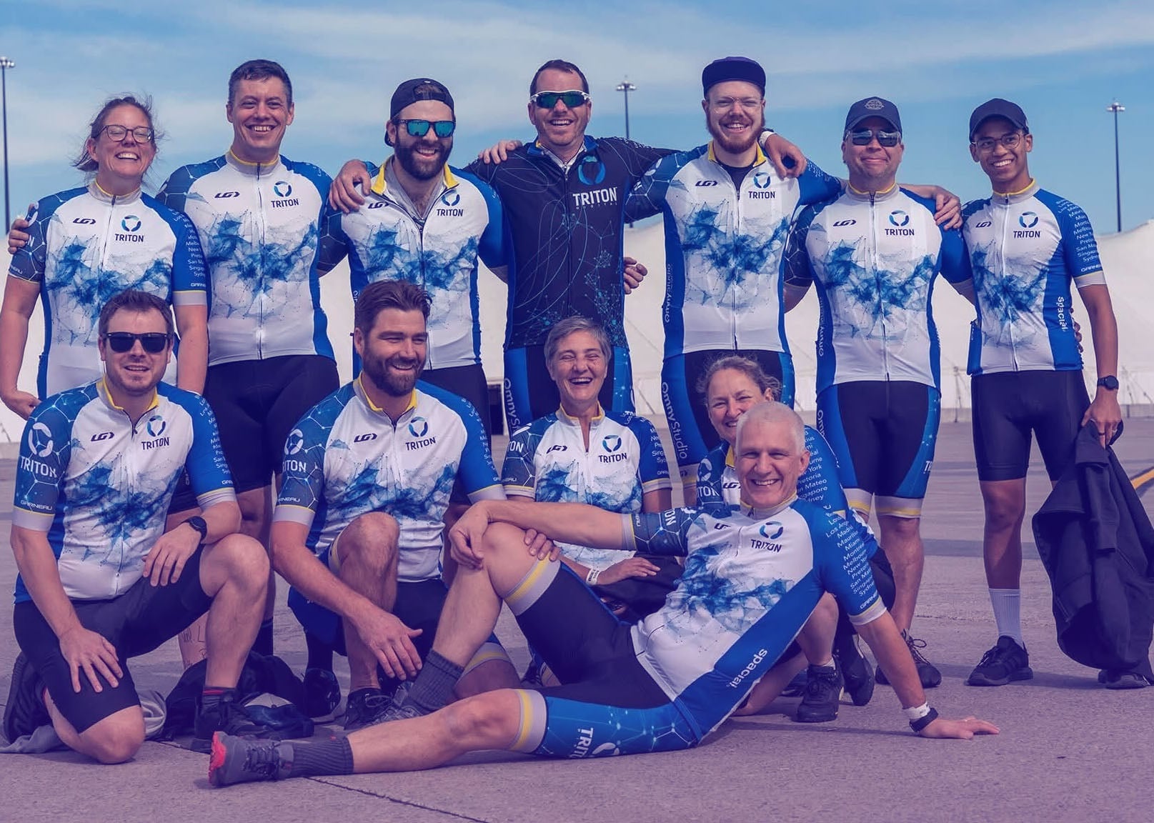 Triton team members posing outdoors in matching branded cycling kit