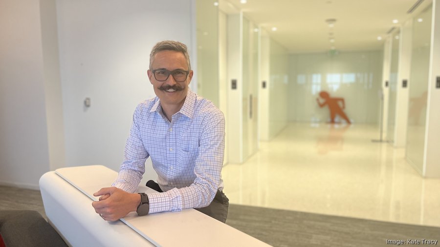 Troy Lerner leaning on a reception counter in Booyah Advertising's Denver office