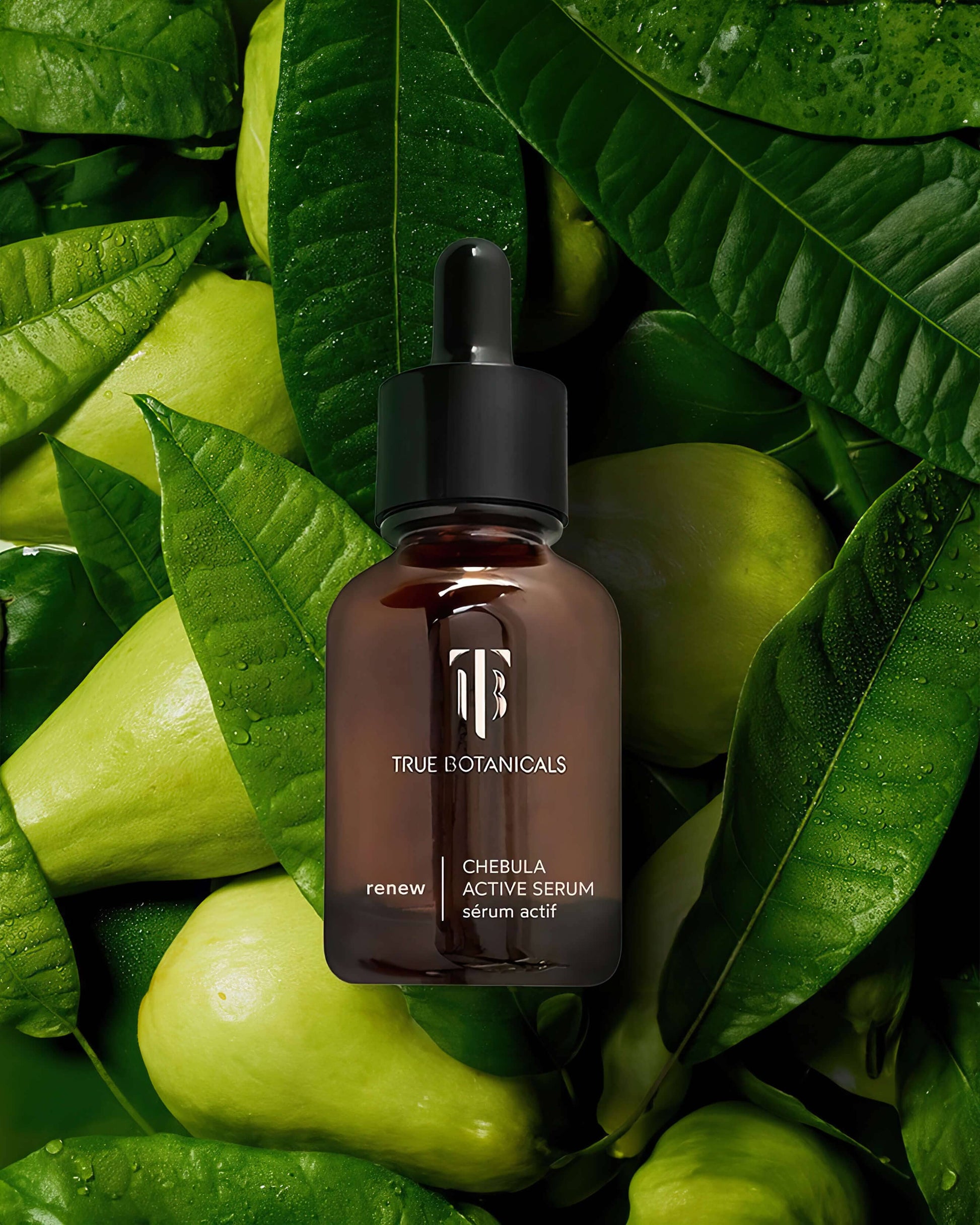 True Botanicals Chebula Active Serum bottle photographed among green leaves