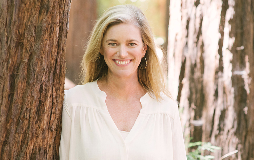 True Botanicals founder Hillary Peterson standing beside a redwood tree