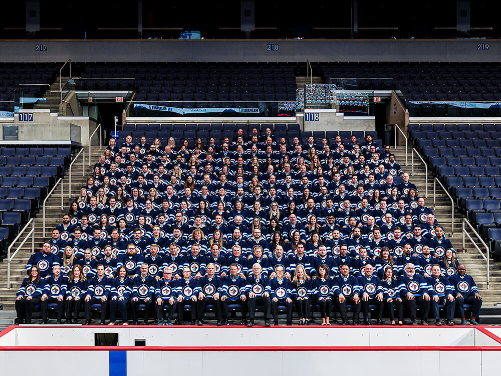 True North Sports and Entertainment employees gathered in Winnipeg Jets jerseys at Canada Life Centre