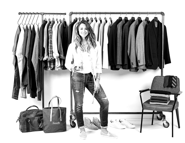 Trumaker Outfitter standing beside racks of shirts and tailored jackets