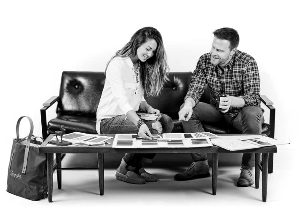 A Trumaker Outfitter and client look through fabric swatches at a consultation