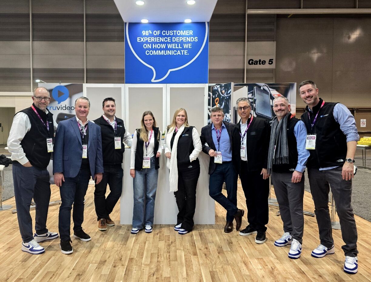 The TruVideo team standing at a trade-show booth