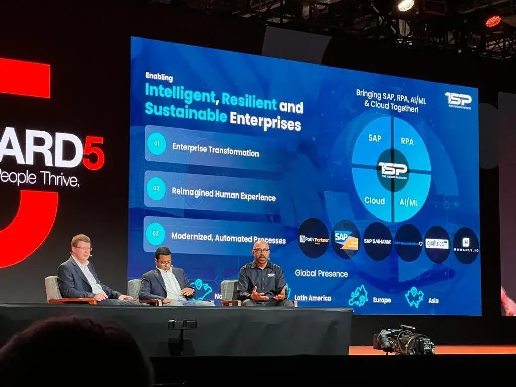 Panelists seated in front of a presentation of TSP’s SAP, automation, AI and cloud services