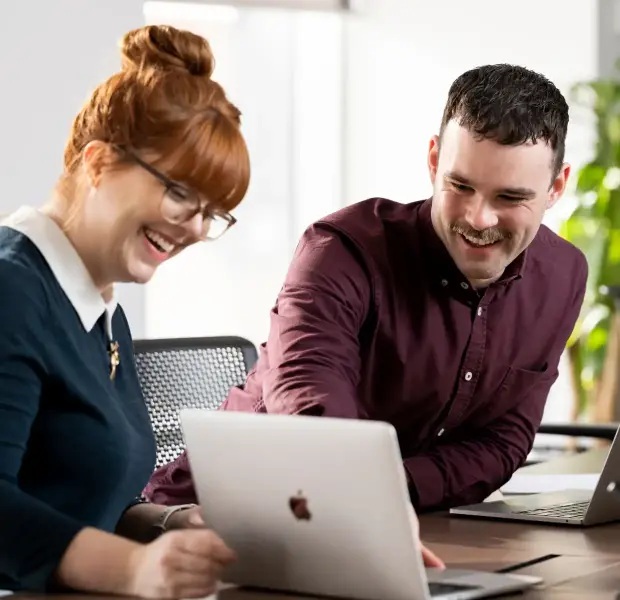 Two people at a laptop in Turnitin’s media-kit photograph
