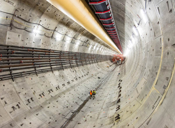 Workers appear small inside the broad concrete-lined bore of Seattle’s SR 99 tunnel