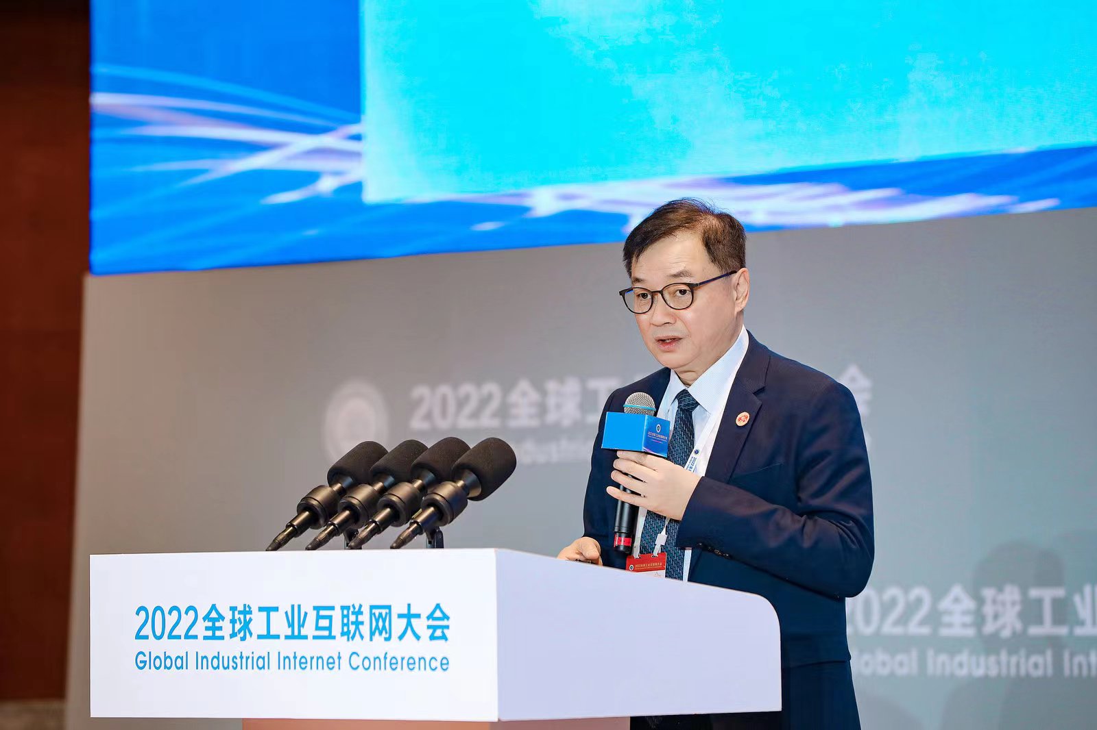 Tianwen Liu speaking into a microphone at the 2022 Global Industrial Internet Conference in Shenyang