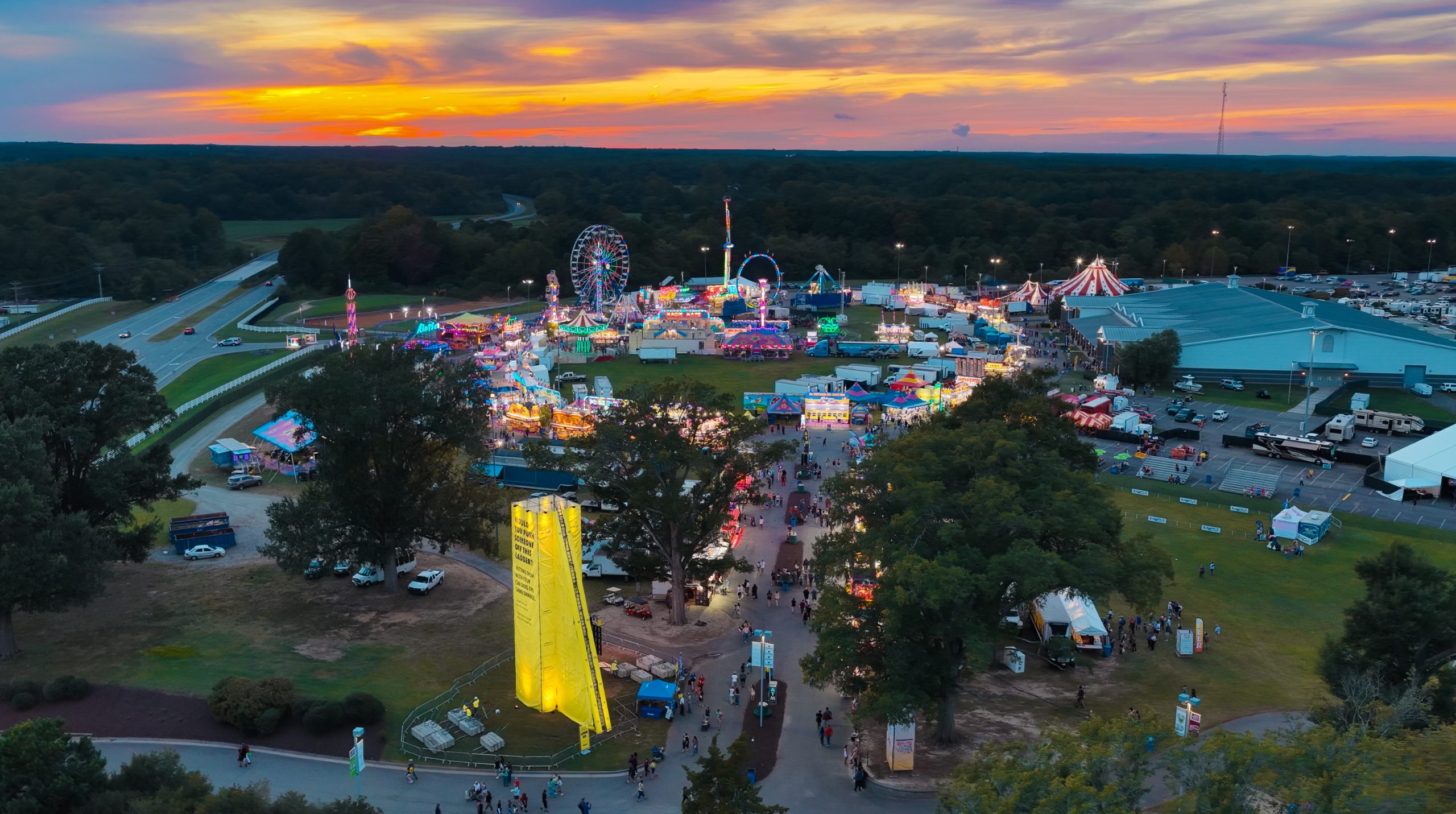 The bright yellow Virginia DMV Speed Ladder rising over an outdoor event