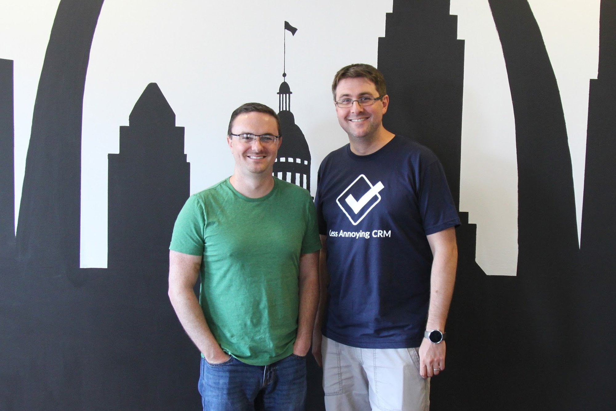 Brothers Bracken and Tyler King standing together in front of a St. Louis skyline mural