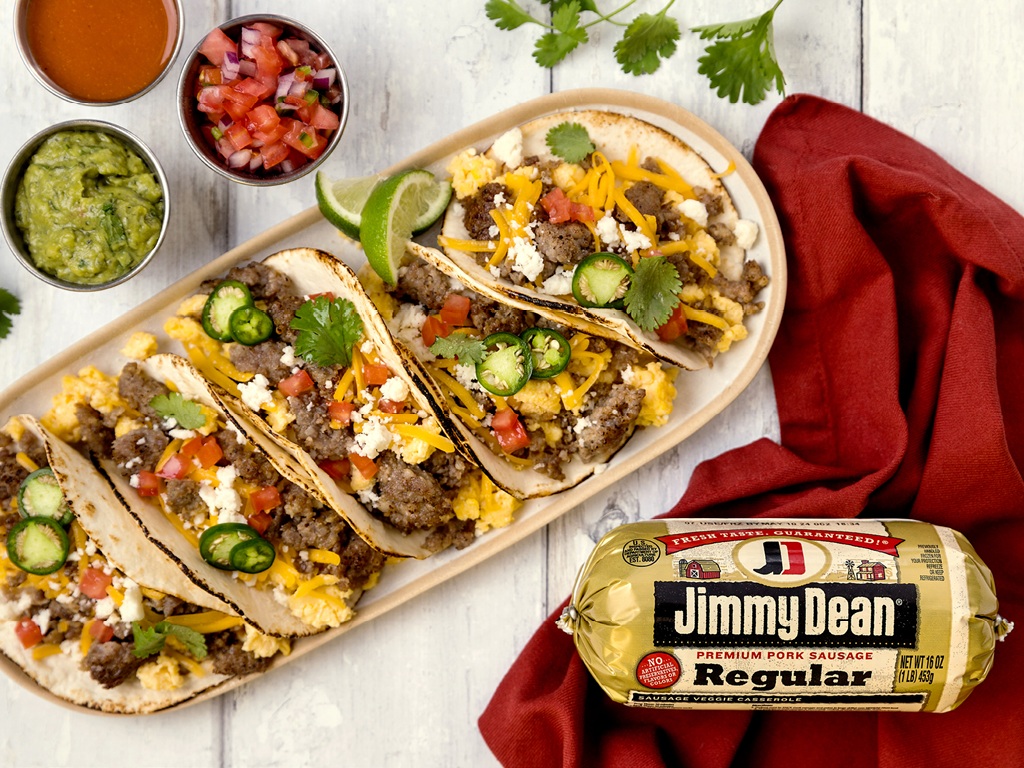 Breakfast tacos with Jimmy Dean sausage, eggs and toppings beside a sausage package