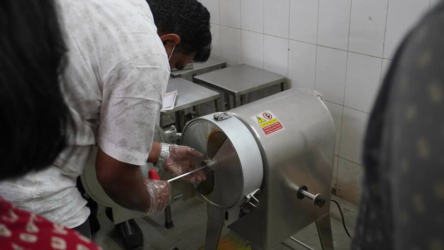 A participant watches food-processing equipment during a practical demonstration