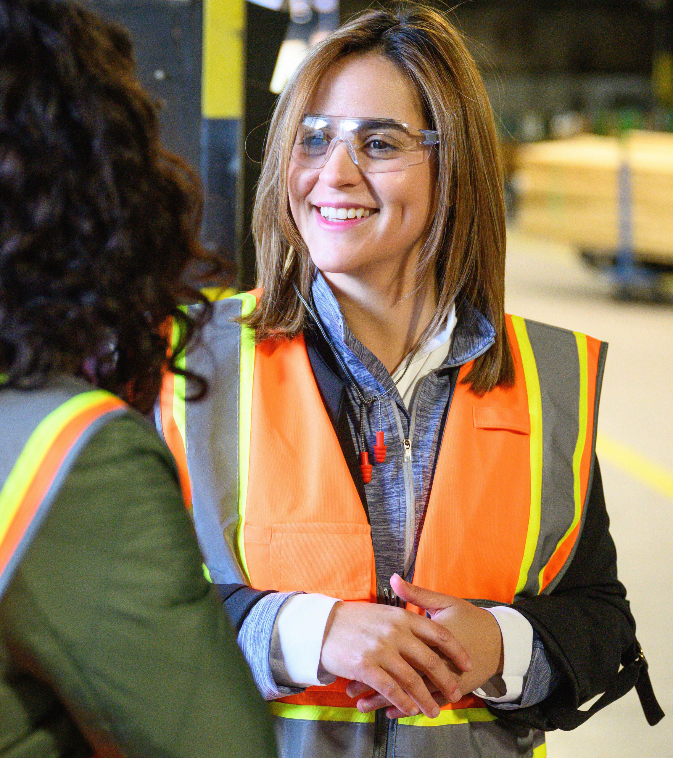 UFP employees talking on a manufacturing floor in safety glasses and high-visibility vests