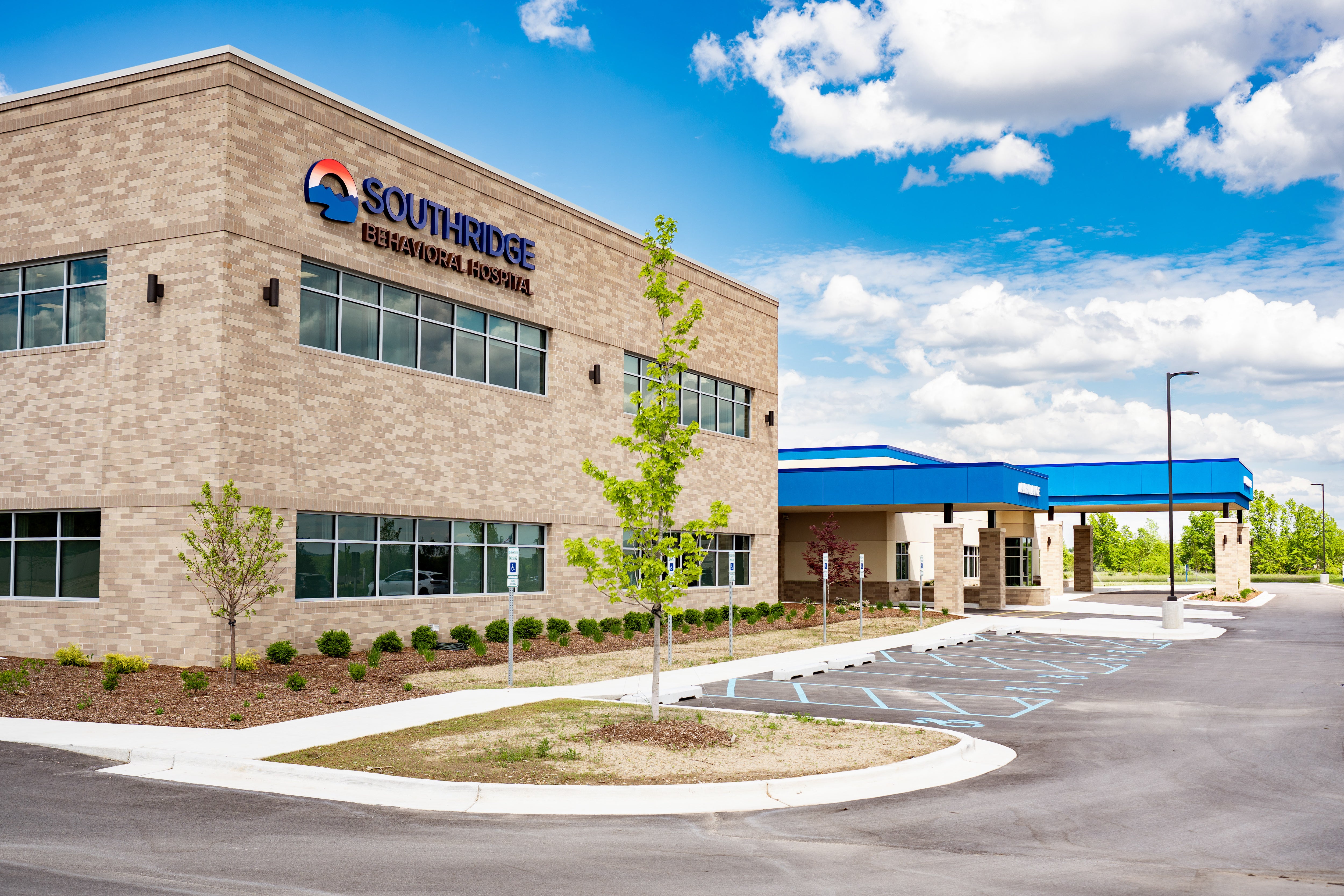 Brick exterior and blue entrance canopy of Southridge Behavioral Hospital