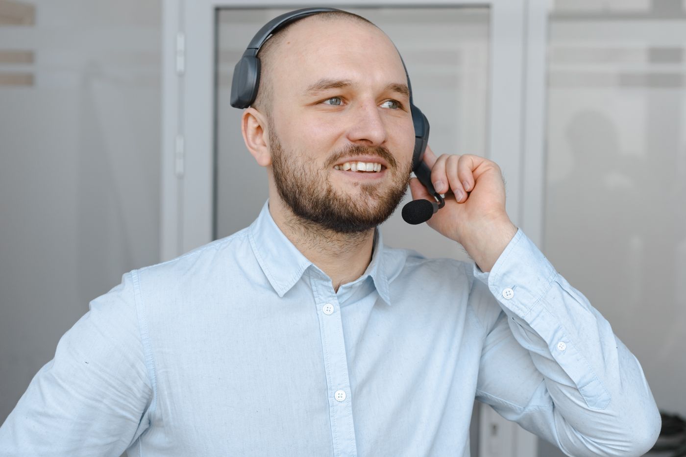 A customer-service agent smiling while speaking through a headset