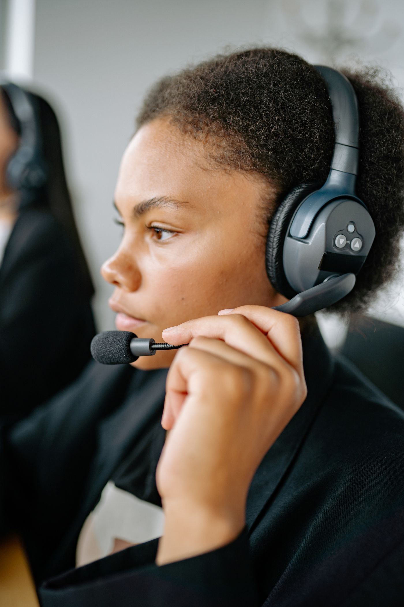 A focused contact-center agent holding a headset microphone