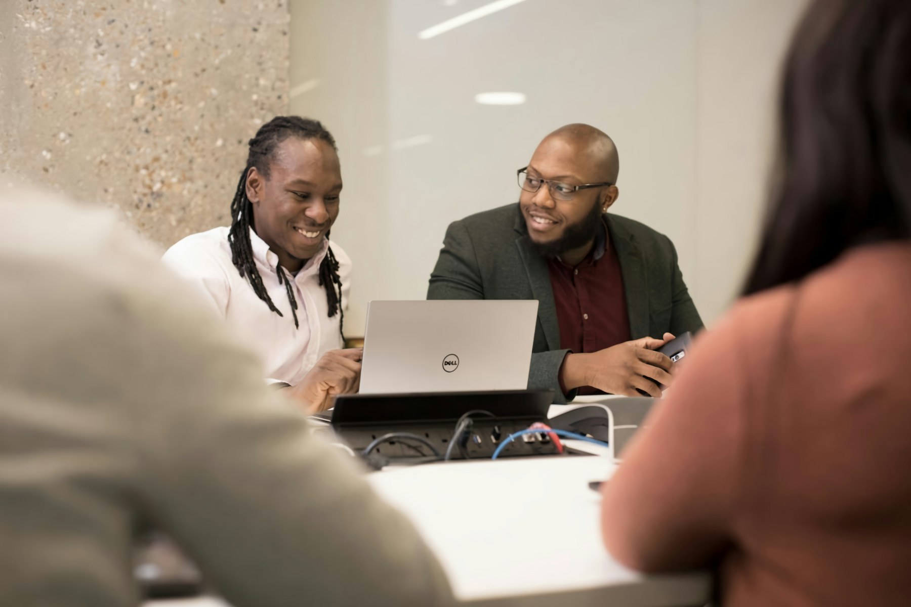 Colleagues reviewing work together around a laptop
