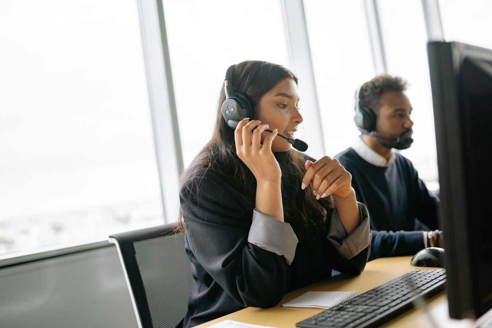 Customer service agents wearing headsets at computers in a contact center