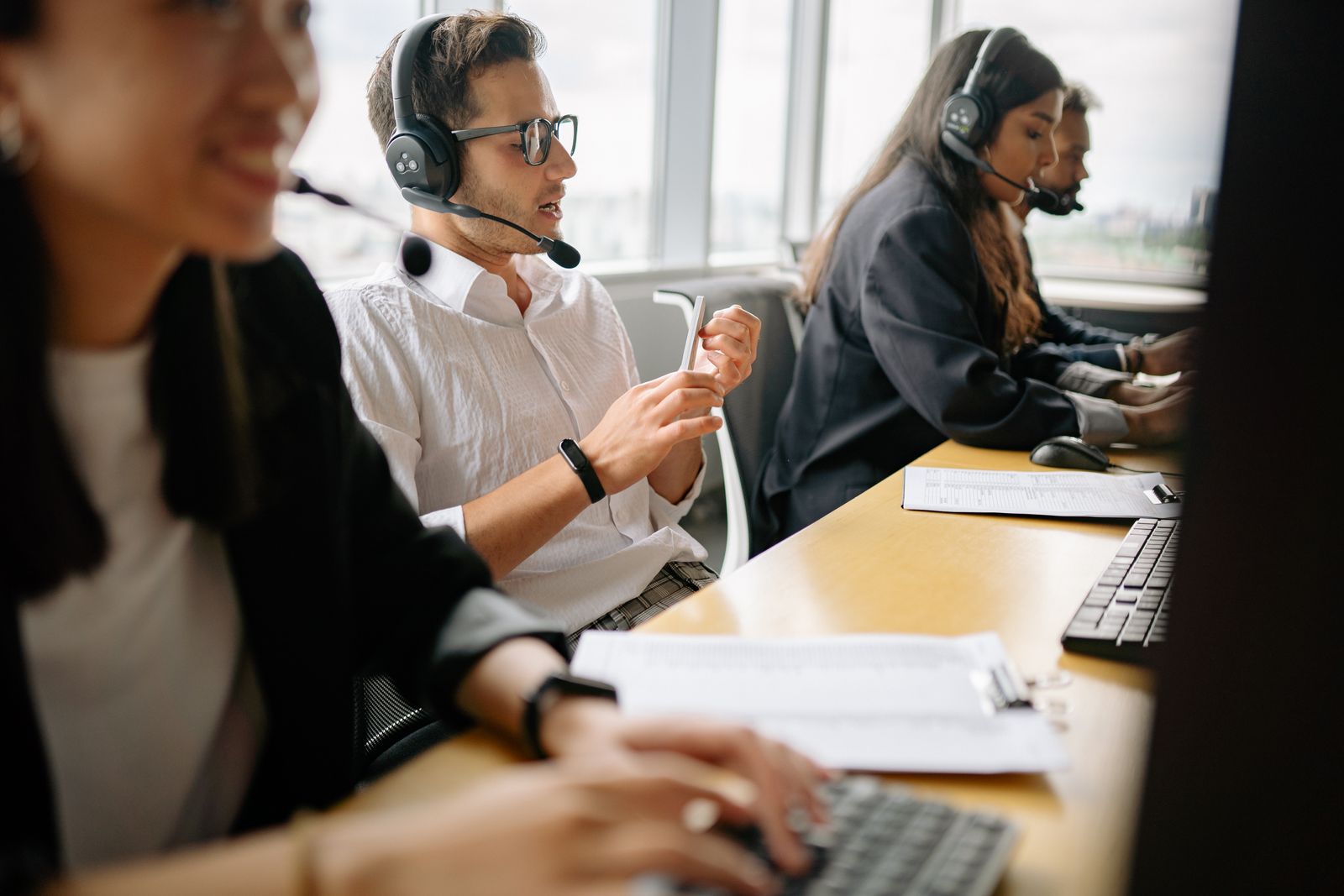Headset-wearing call center colleagues working at computers