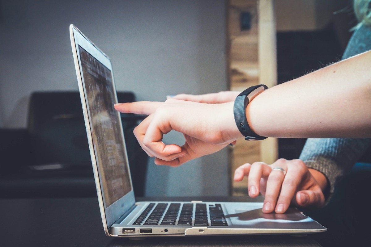 Two people reviewing information on a laptop