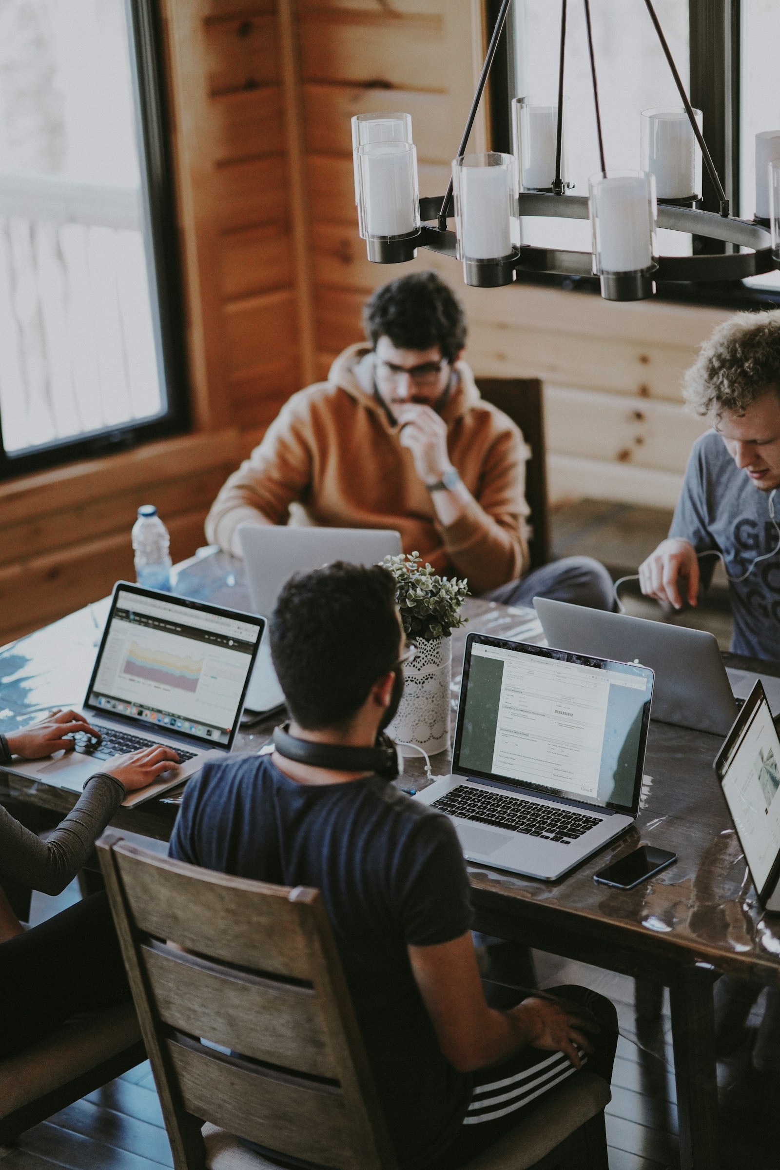A team works together on laptops around a table