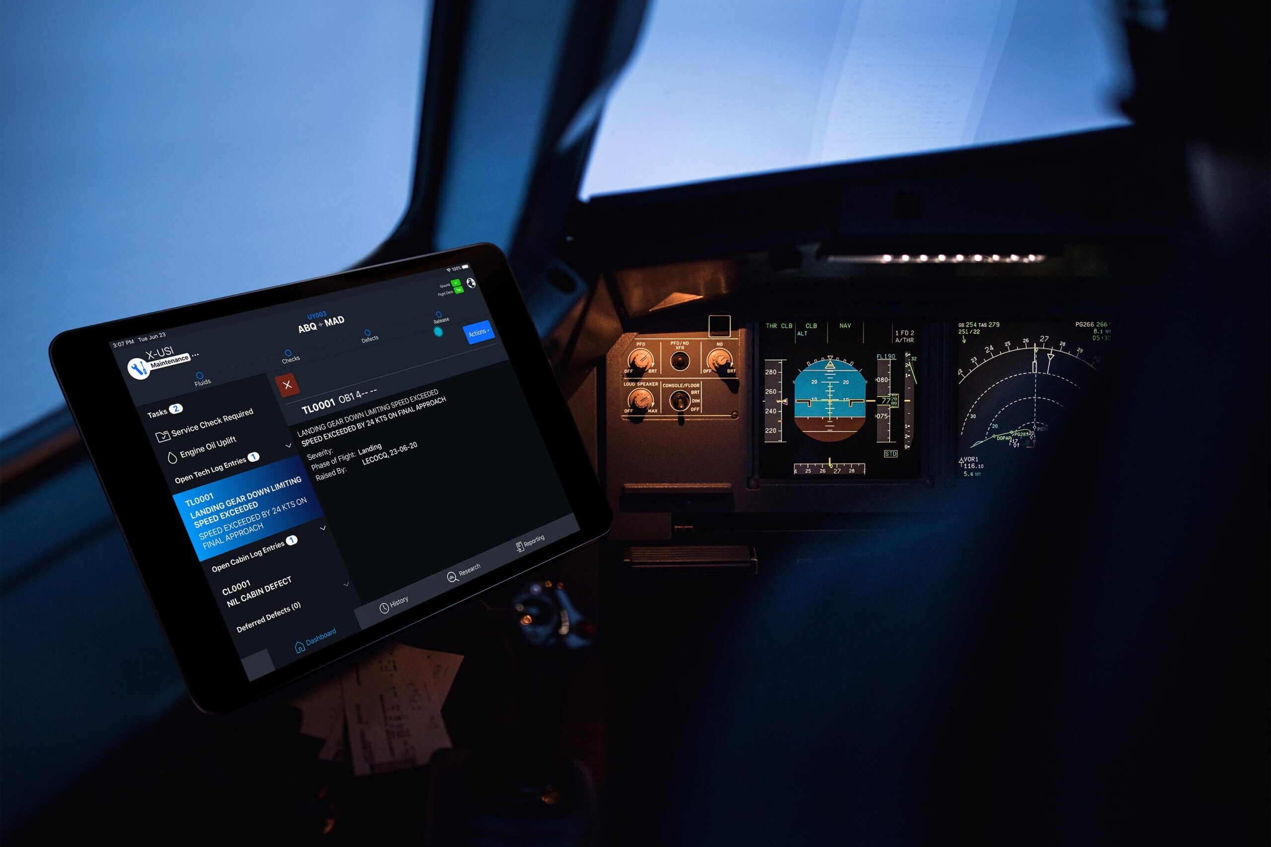 Ultramain electronic logbook displayed on a tablet beside aircraft cockpit instruments