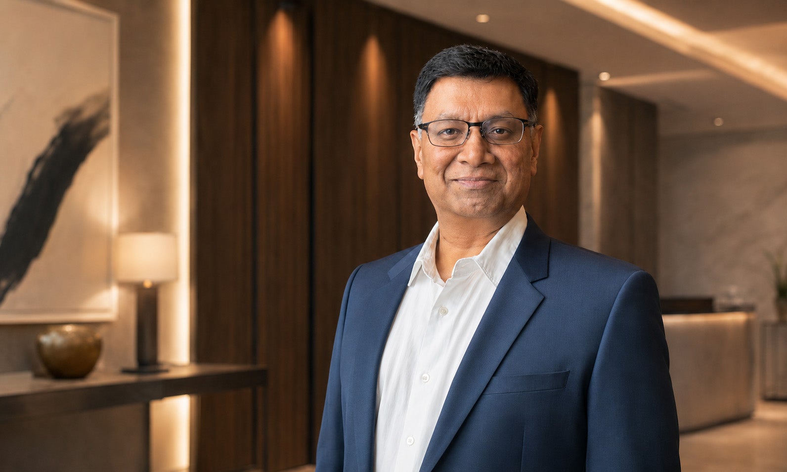Umesh Tibrewal wearing a navy jacket in a wood-panelled interior