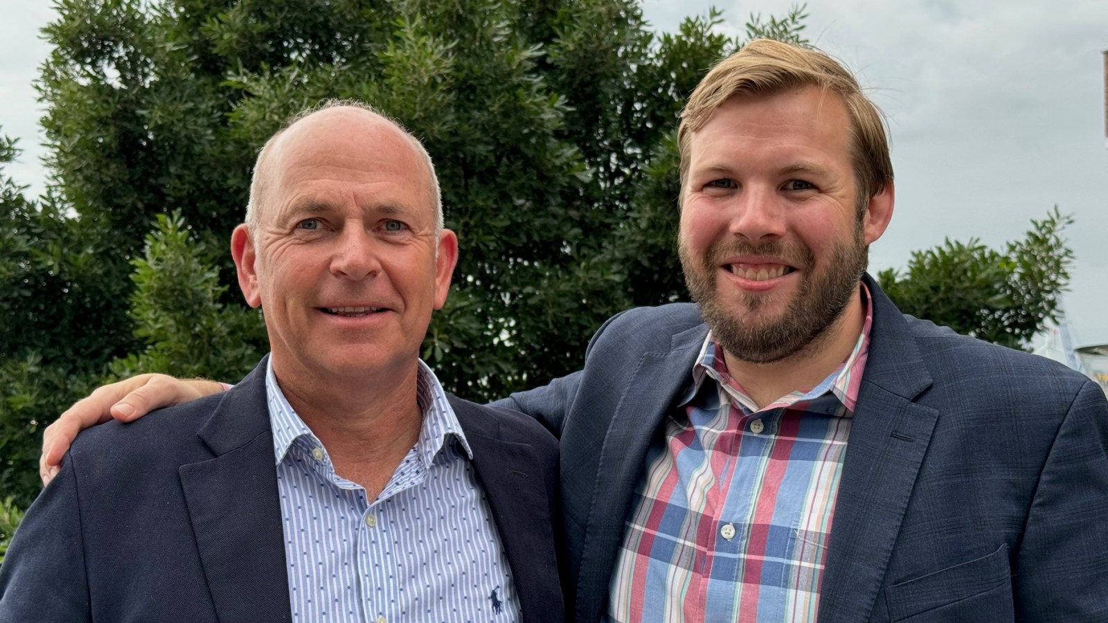 Understory executives Neil Irwin and Alex Kubicek standing beside the company's weather sensor