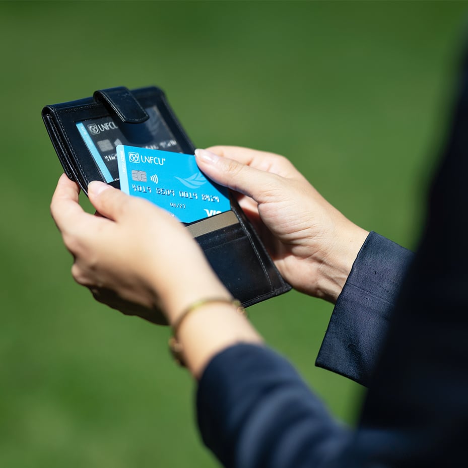 A wallet holding UNFCU credit cards