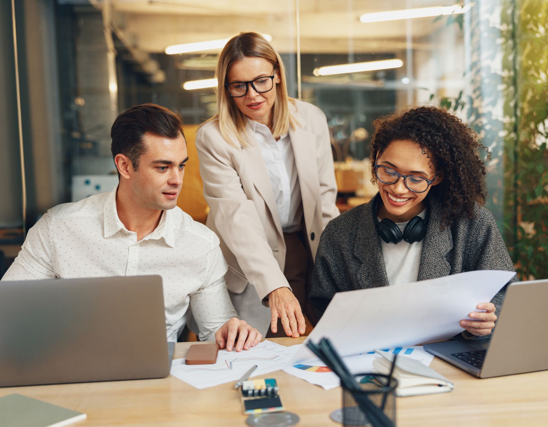 Three people reviewing documents together at a desk, an illustrative image used on UnisLink’s website