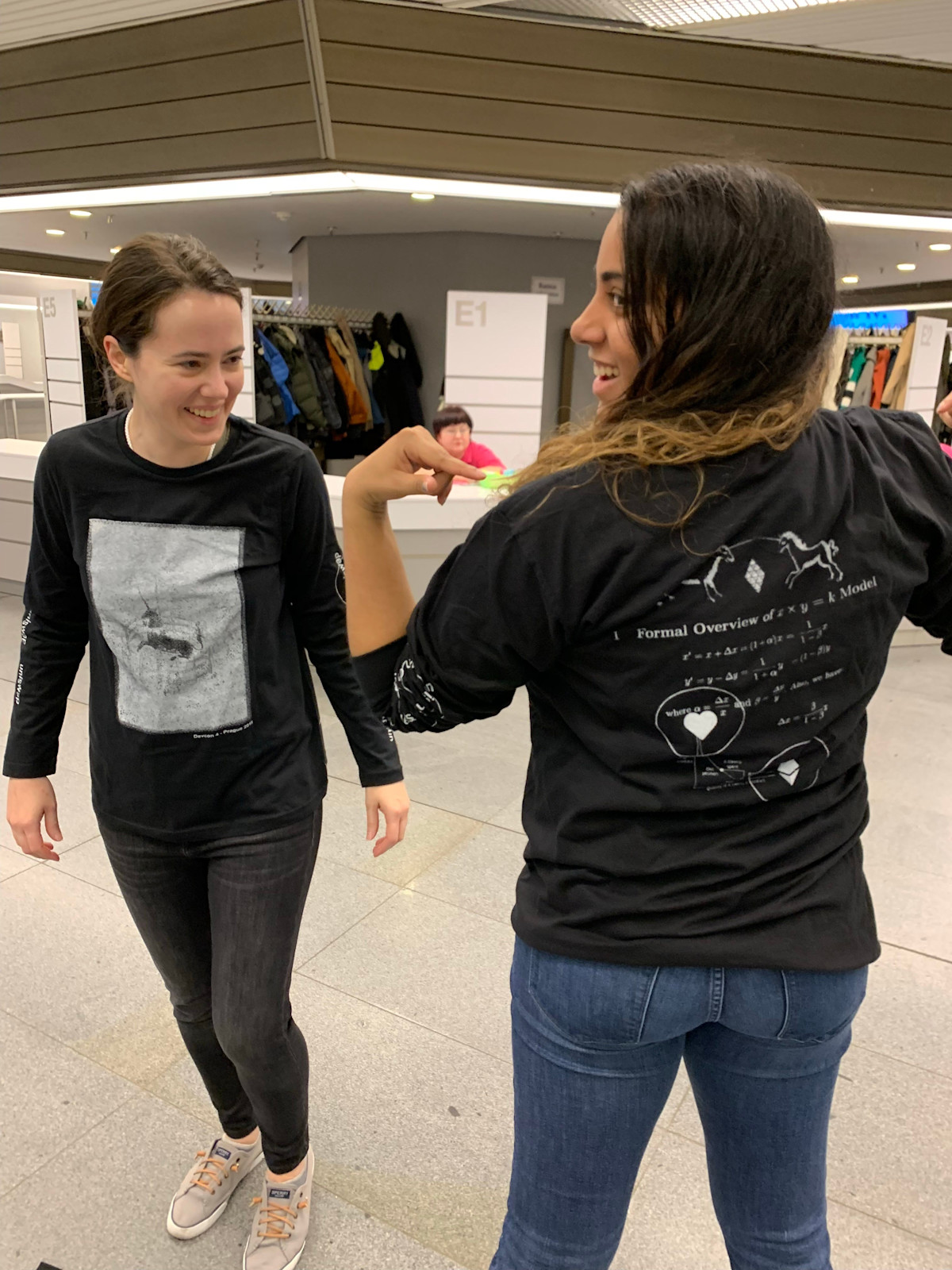 Devcon attendees showing Uniswap T-shirts printed with market-making mathematics