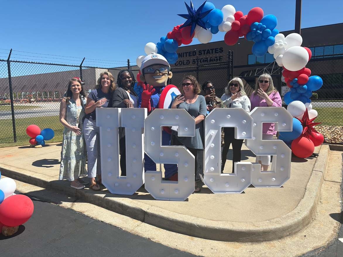 USCS staff celebrating outside the McDonough facility with balloons and the company mascot