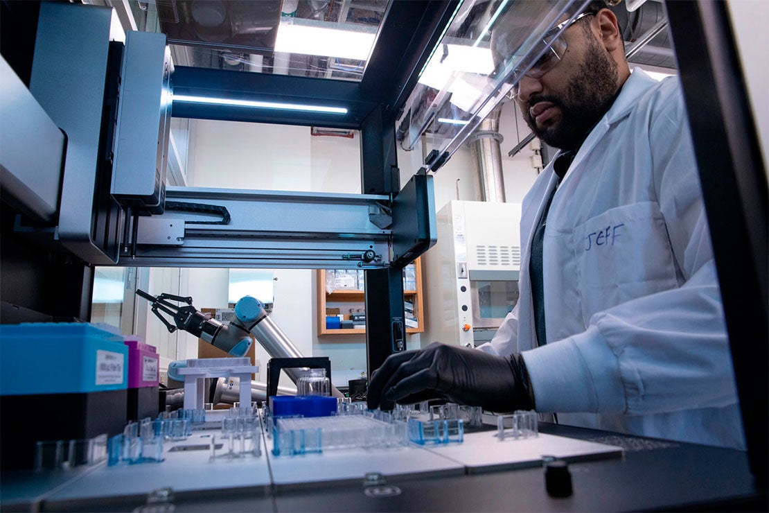 A researcher works with automated equipment in the University of Toronto Acceleration Consortium laboratory