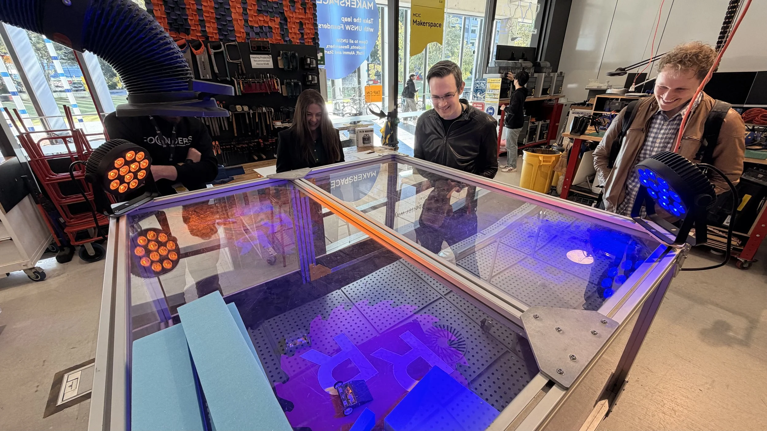 Visitors gathered around fabrication equipment in the MCIC Makerspace