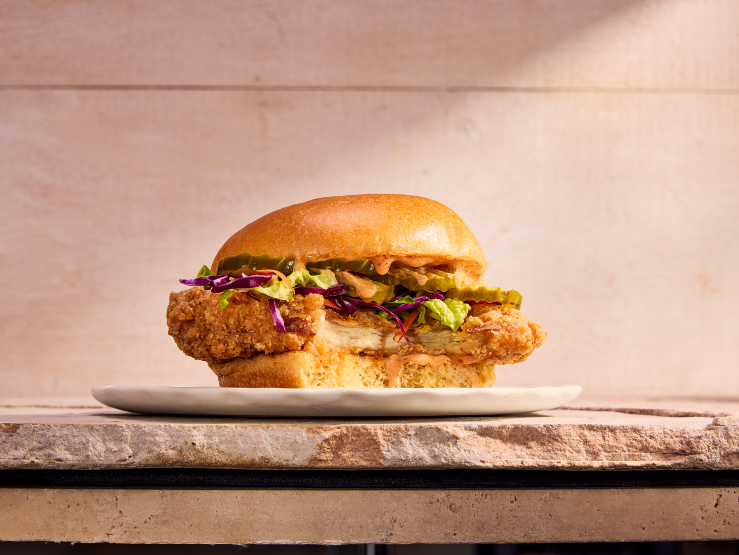 A fried cultivated chicken sandwich cut to show the breaded filet inside