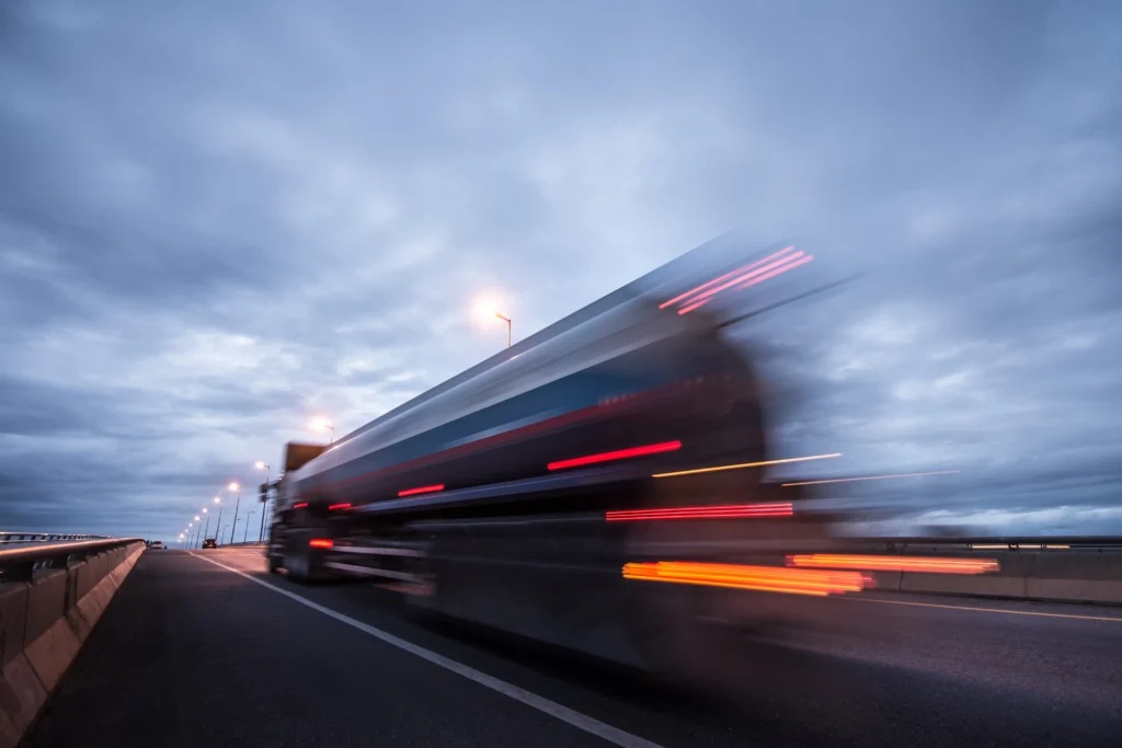 A truck moving along a highway at dusk