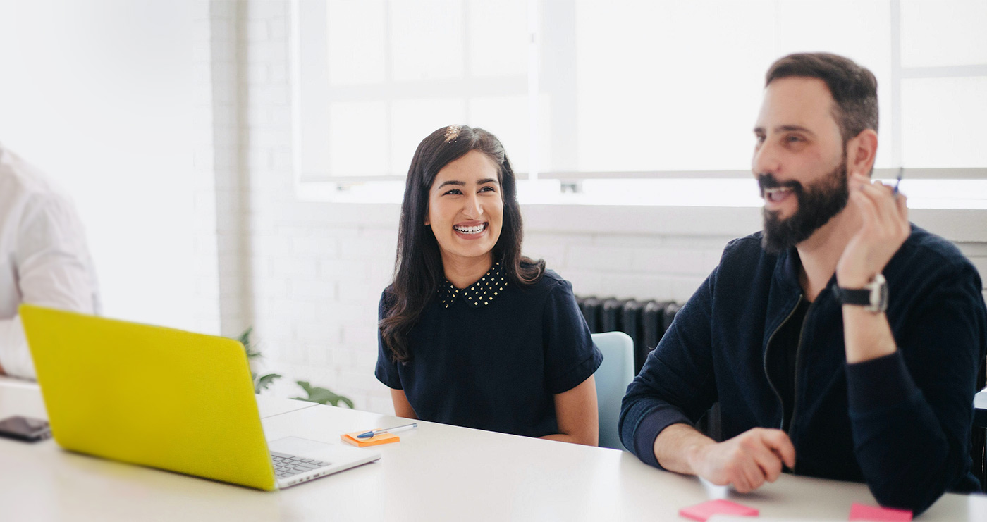Two people talking across a table in a workplace photograph published by U.S. FinTech