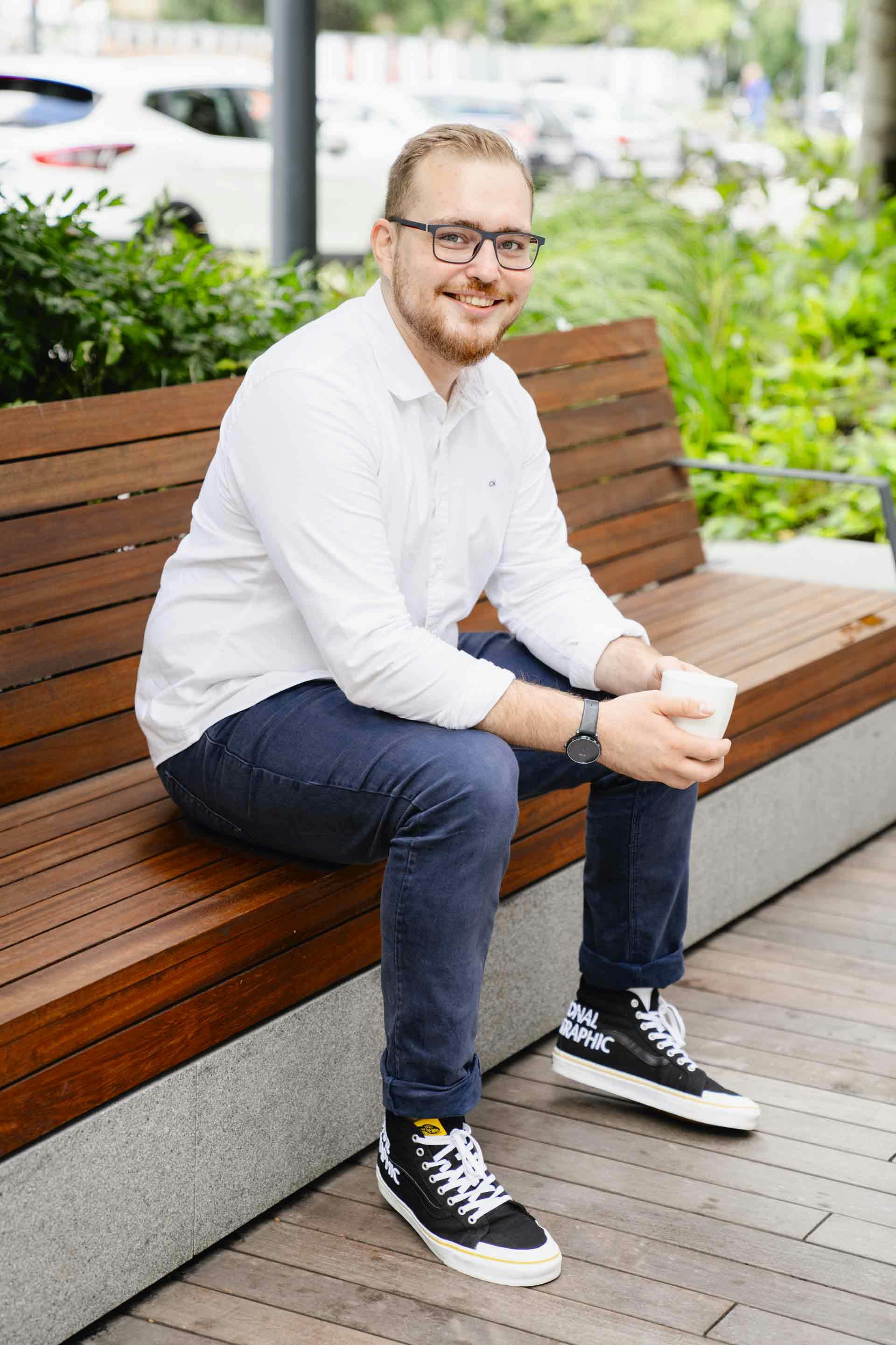 Vadym Melnyk seated outdoors on a wooden bench