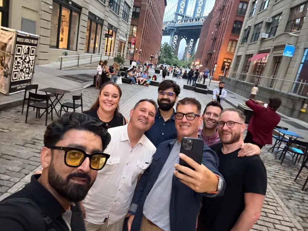 Vaibhav Antil, in a navy shirt near the center, with a group from Privado in Brooklyn, with the Manhattan Bridge behind them